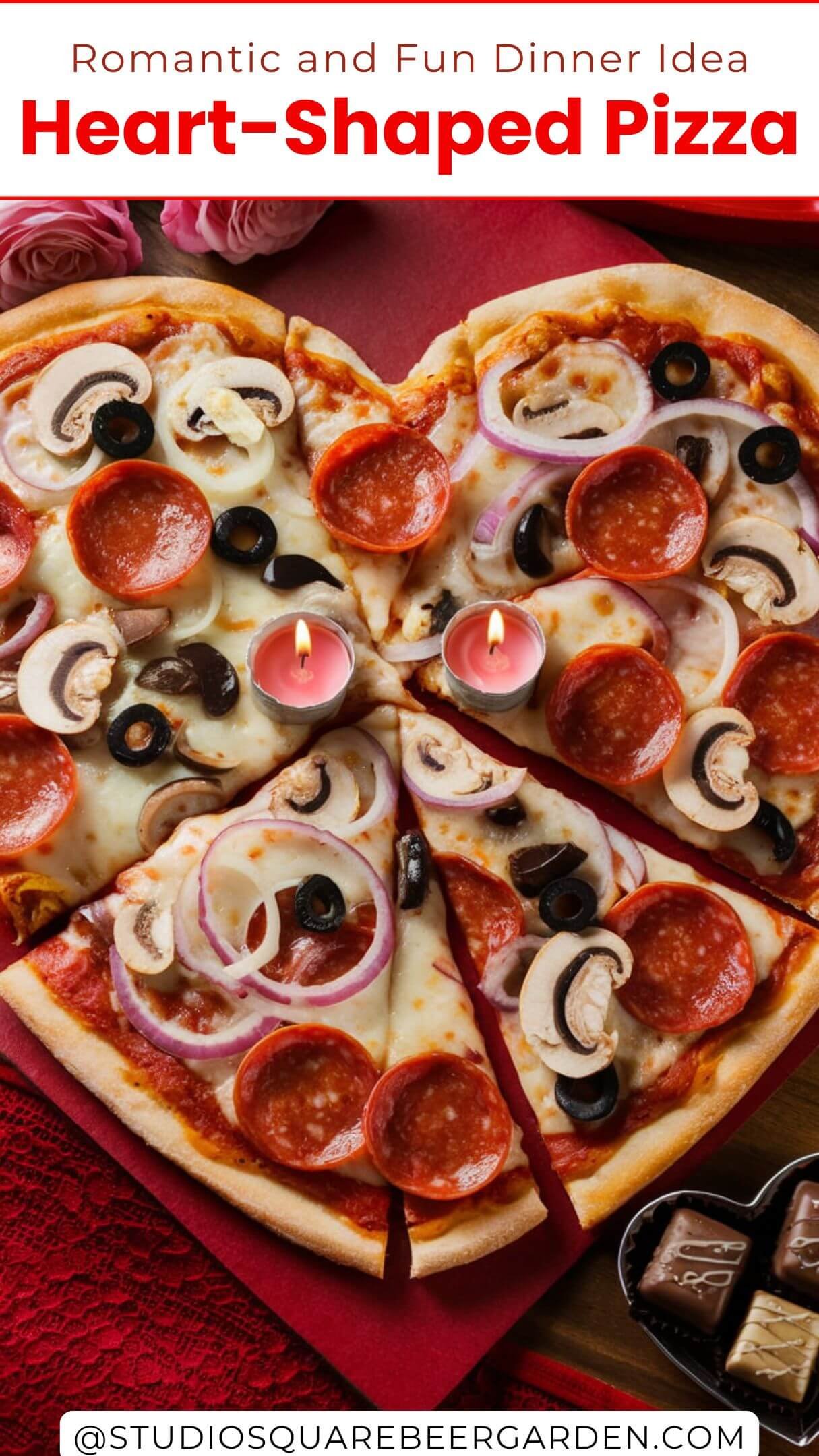 A heart-shaped pizza with toppings of pepperoni, mushrooms, onions, and olives. The pizza is cut into two slices. There are two candles on the pizza. The background is a wooden table with a red tablecloth. There are roses and a heart-shaped box of chocolates beside the pizza.